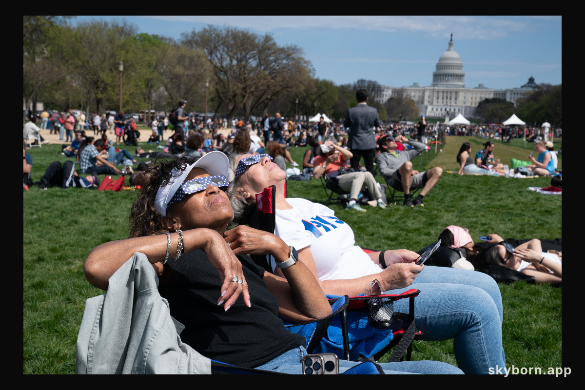 Patricia Jones (left) and Renee Chapman (right) view a partial solar eclipse in Washington, DC, Monday, April 8, 2024