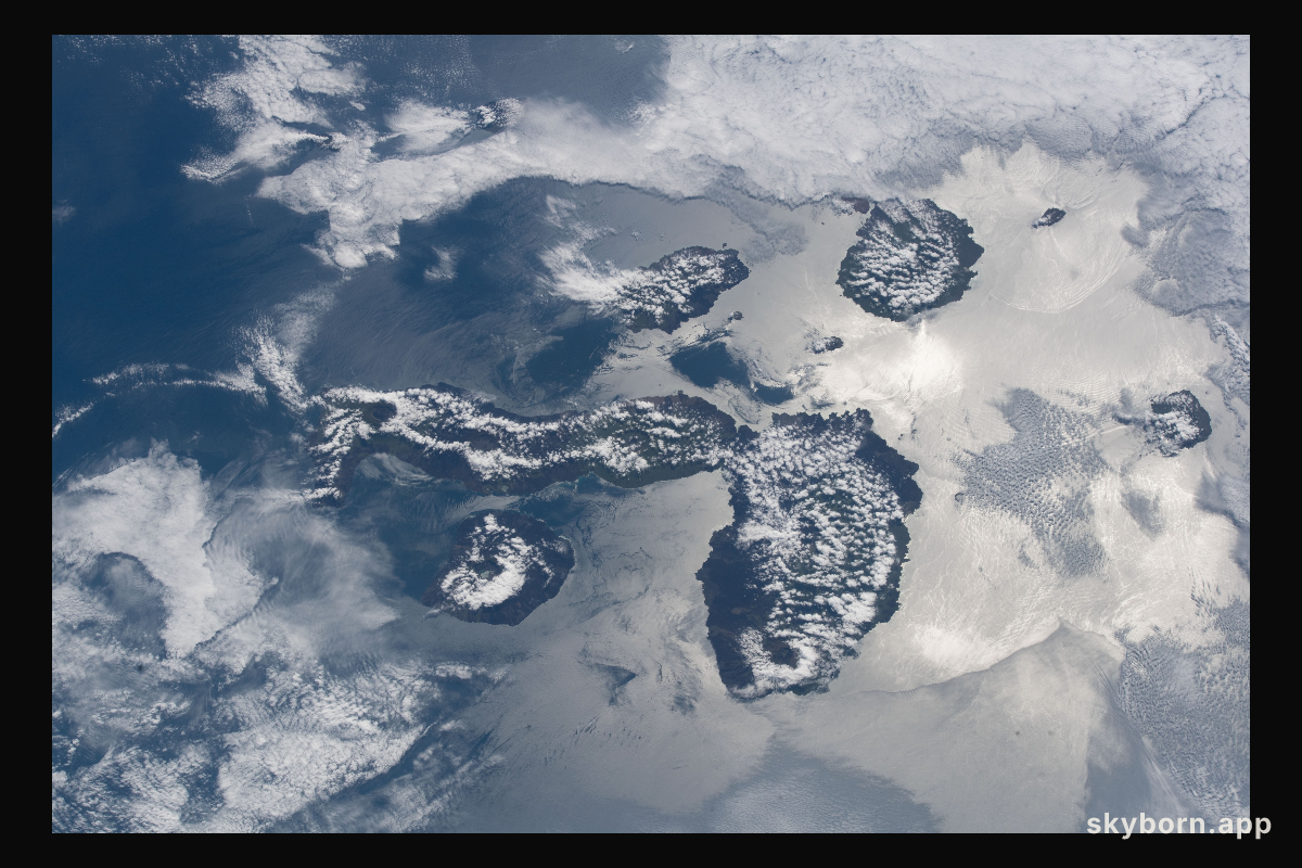 The cloud-covered Galapagos Islands and the sun's glint in the waters off the coast of Ecuador are pictured