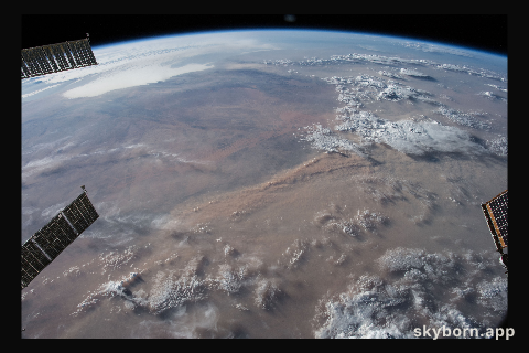 Earth's limb and dust storms in the Sahara are pictured as the International Space Station orbited nearly 252 miles