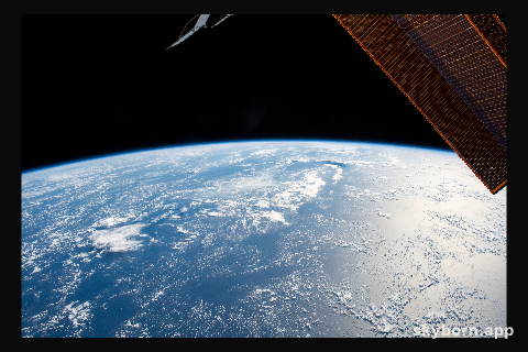 The Sun's glint beams off the blue waters of the Pacific Ocean as the International Space Station orbited 254 miles
