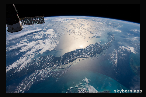 The International Space Station orbits 255 miles above the Atlantic Ocean looking southwest over Cuba as the Sun's