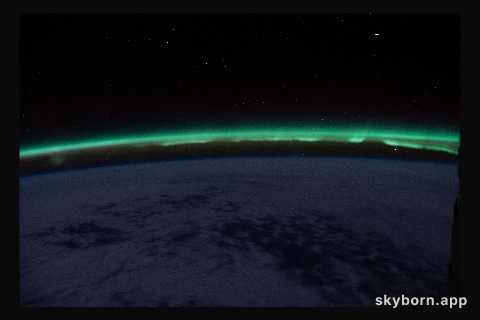 The "aurora australis" hovers above the Earth's horizon as the International Space Station nears the southern-most