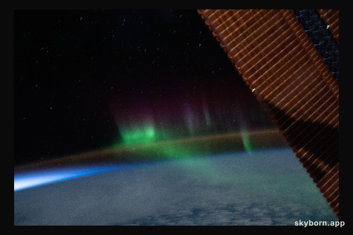 A wispy "aurora australis" seemingly intersects with the Earth's airglow as the International Space Station orbited