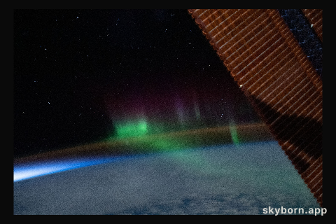 A wispy "aurora australis" seemingly intersects with the Earth's airglow as the International Space Station orbited