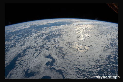 The sun's glint beams on the South Pacific Ocean as the International Space Station orbited just off the coast