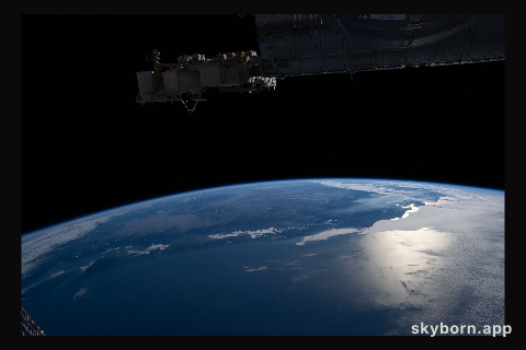 The Earth's limb, or horizon, with the Sun's glint beaming off the Pacific Ocean and San Francisco Bay, is pictured