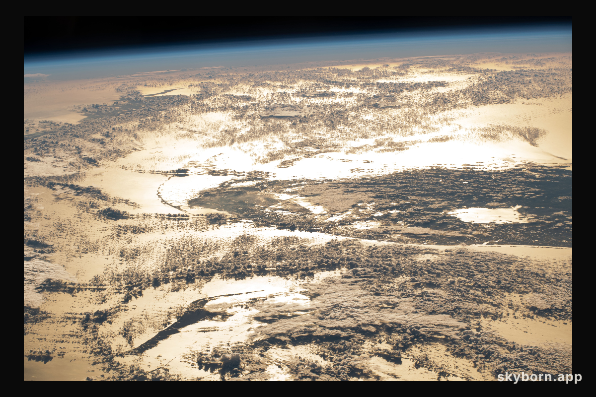 The sun's glint beams off the Atlantic Ocean creating a bright golden sheen as the International Space Station orbited