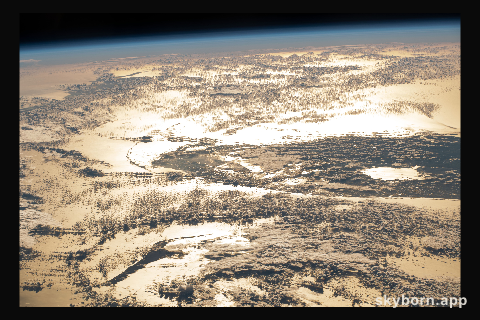 The sun's glint beams off the Atlantic Ocean creating a bright golden sheen as the International Space Station orbited