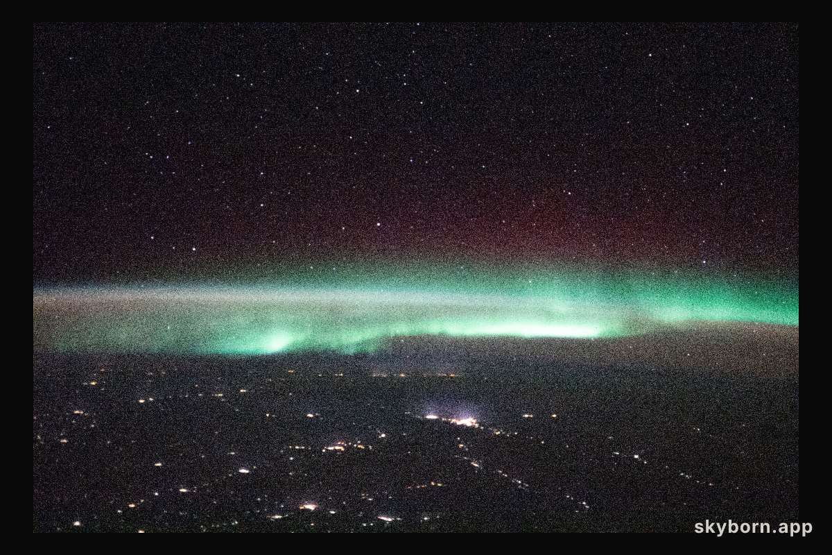 A starry night sky and an aurora are pictured above Russia as the International Space Station orbited 264 miles