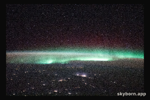 A starry night sky and an aurora are pictured above Russia as the International Space Station orbited 264 miles