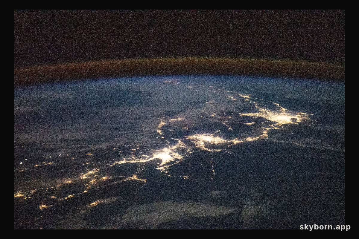 The city lights of Japan, blanketed by the air glow above Earth's horizon, are pictured from International Space