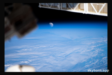 The Moon pictured during a lunar eclipse, and intersecting with the Earth's horizon, is seen from the International