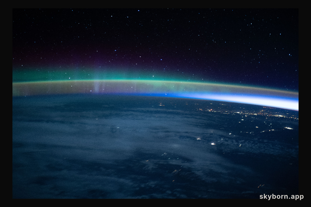 An aurora dimly intersects with Earth's airglow as the International Space Station flew into an orbital sunrise 264