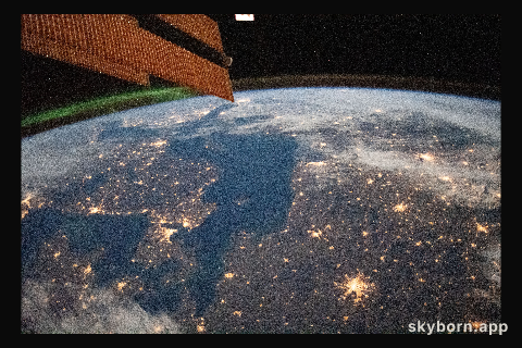 A faint aurora and the Earth's atmospheric glow crown this night time photograph of Northern Europe,