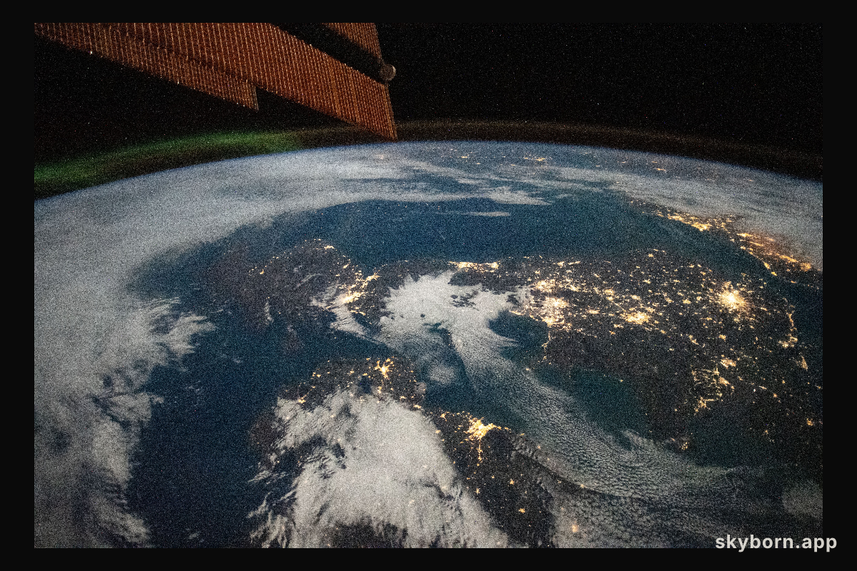 A faint aurora and the Earth's atmospheric glow crown this night time photograph of Ireland, Great Britain,