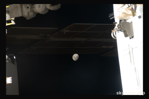 The Moon, with Earth's shadow draping across it during a lunar eclipse, is pictured in a gap in between International