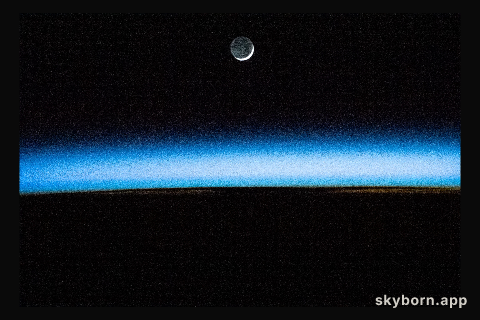 The waxing crescent Moon is pictured above Earth's atmosphere illuminated by an orbital sunset as the International