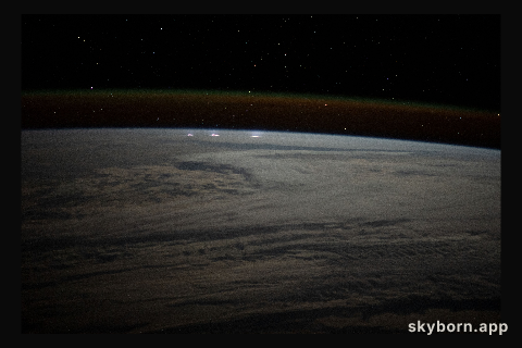 A cloudy, south Indian Ocean between Africa and Antarctica, with lightning storms near the horizon beneath
