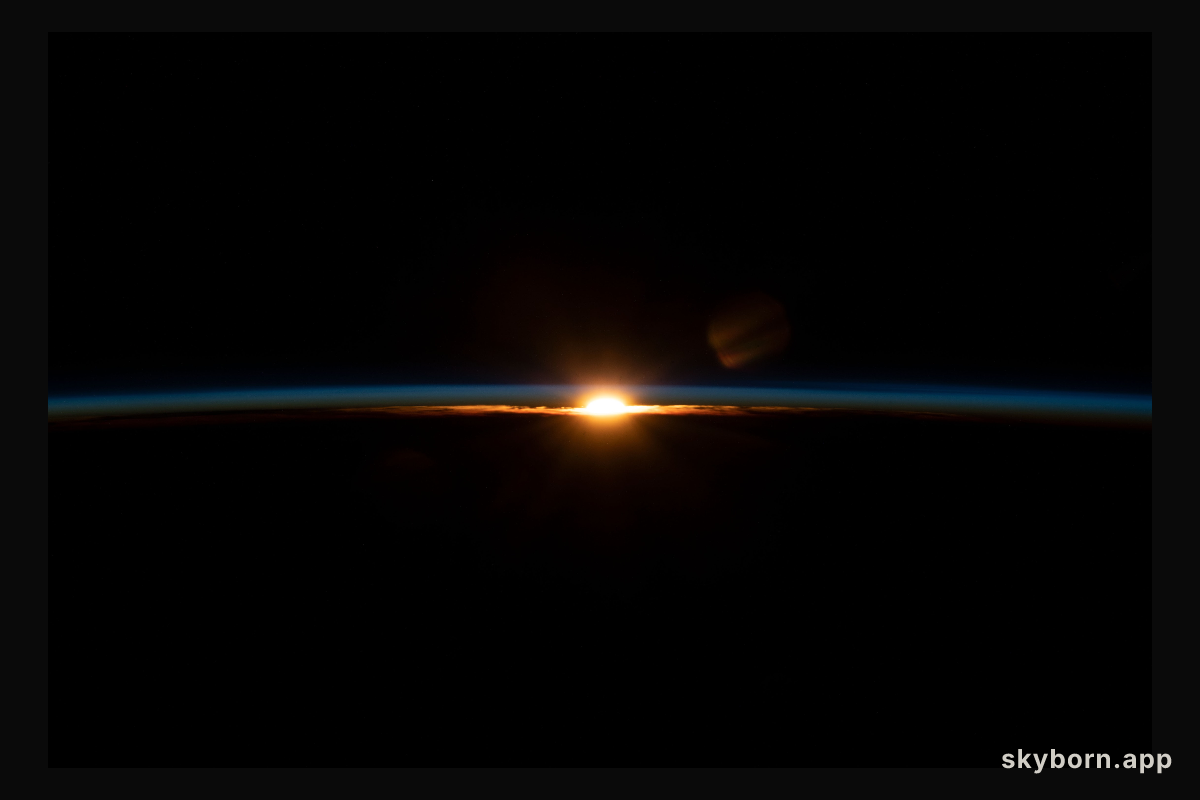The sun's last rays illuminate Earth's thin atmosphere during an orbital sunset in this photograph