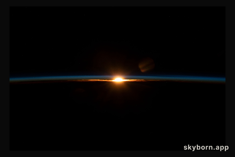 The sun's last rays illuminate Earth's thin atmosphere during an orbital sunset in this photograph