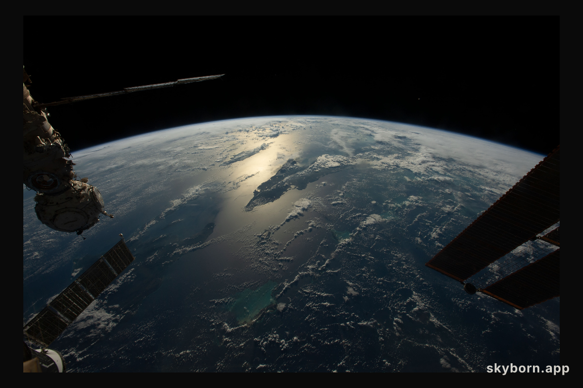 The sun's glint beams across the Caribbean Sea and the Atlantic Ocean highlighting Cuba and Haiti in this photograph