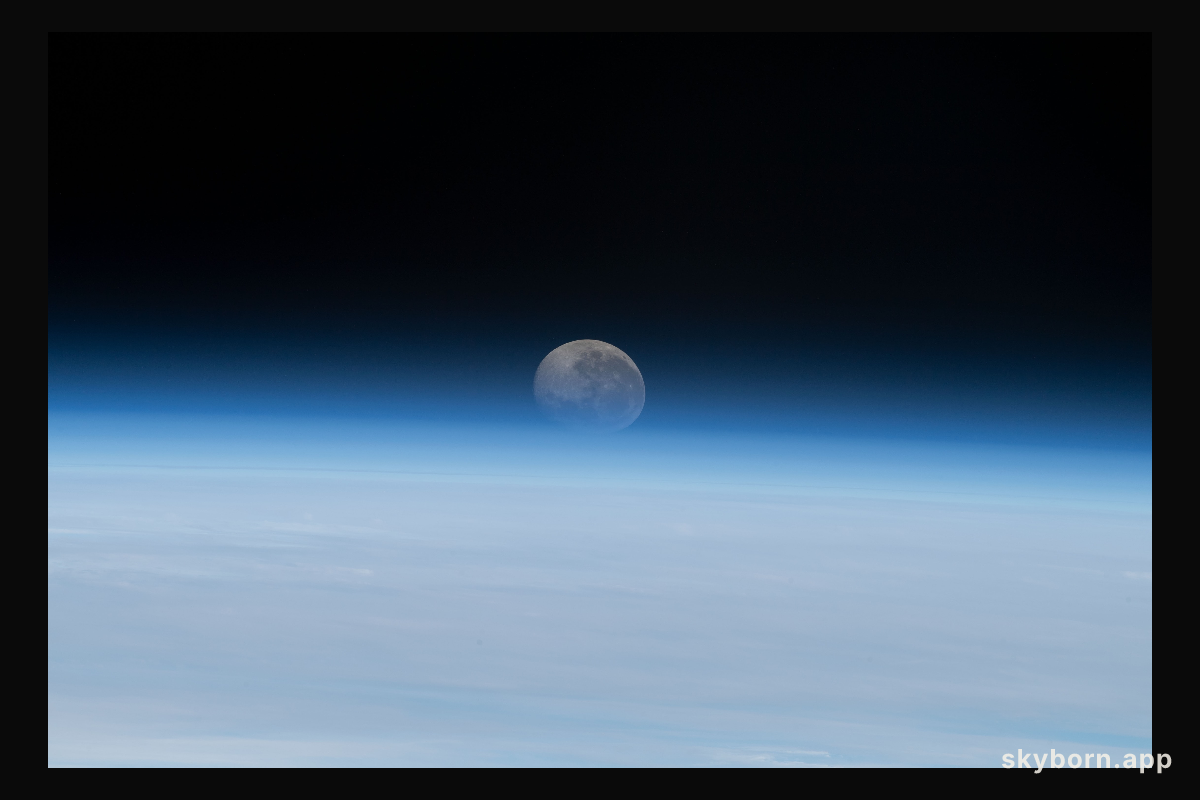 The Moon begins setting below Earth's horizon the atmosphere refracting, or bending, its light making it appear flatter