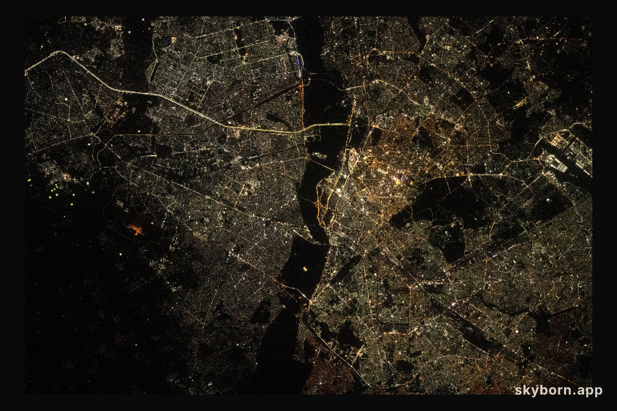 The city lights of New Delhi, India, are split by the darkness of the Yamuna River in this photograph