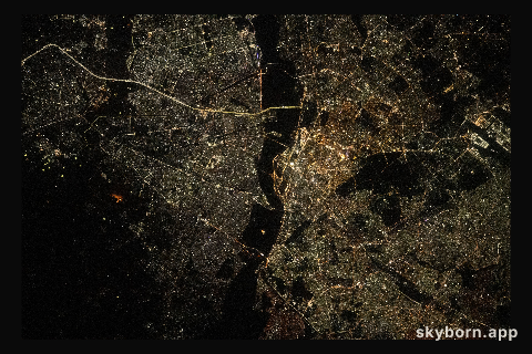 The city lights of New Delhi, India, are split by the darkness of the Yamuna River in this photograph