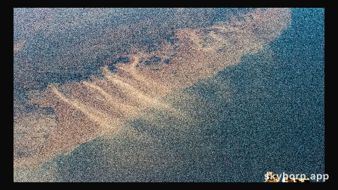 Windblown sand drifts across the Namib desert on the African continent and into the Atlantic Ocean in this photograph