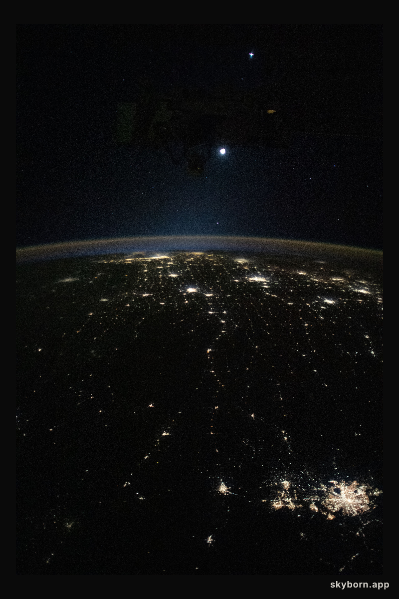 Earth's airglow outlines the planet's horizon with the Moon above in this photograph from the International Space