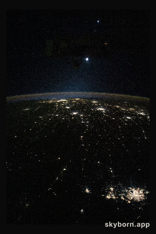 Earth's airglow outlines the planet's horizon with the Moon above in this photograph from the International Space