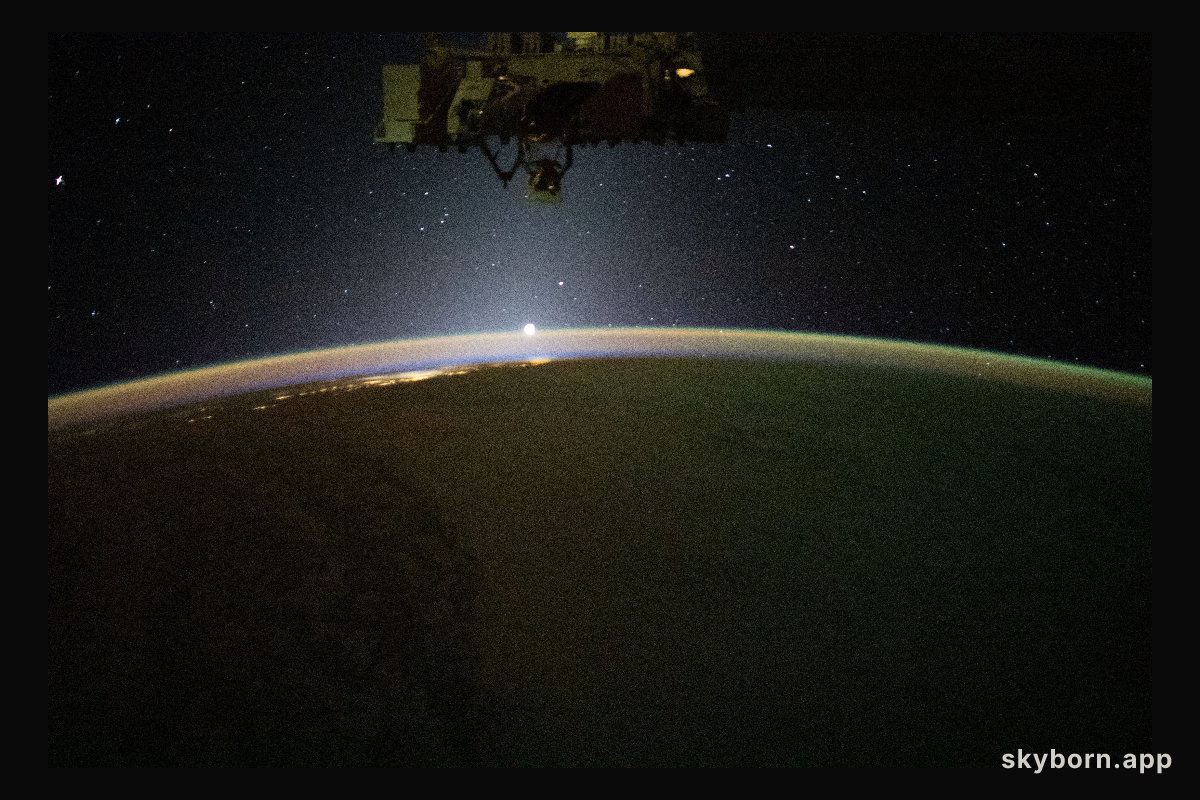 The sun's first rays begin illuminating Earth's atmosphere in this photograph from the International Space Station