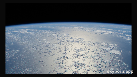 The sun's glint beams off a tranquil, blue Atlantic Ocean in this photograph from the International Space Station as it