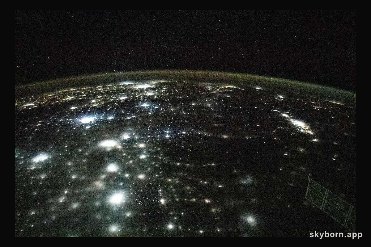 The city lights of North America appear under Earth's airglow and a starry night sky in this photograph