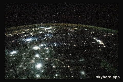 The city lights of North America appear under Earth's airglow and a starry night sky in this photograph