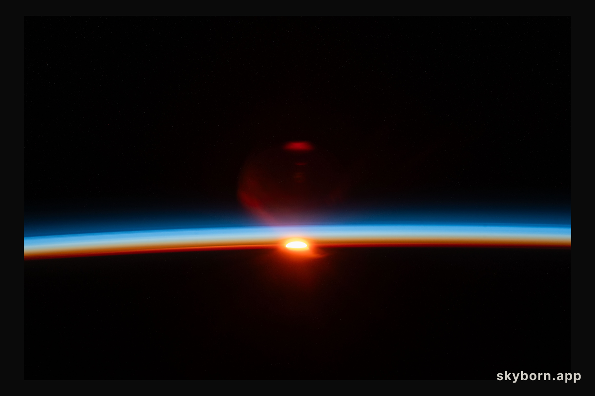 The sun's last rays illuminate Earth's atmosphere and refract in the camera lense in this photograph of an orbital