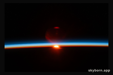 The sun's last rays illuminate Earth's atmosphere and refract in the camera lense in this photograph of an orbital