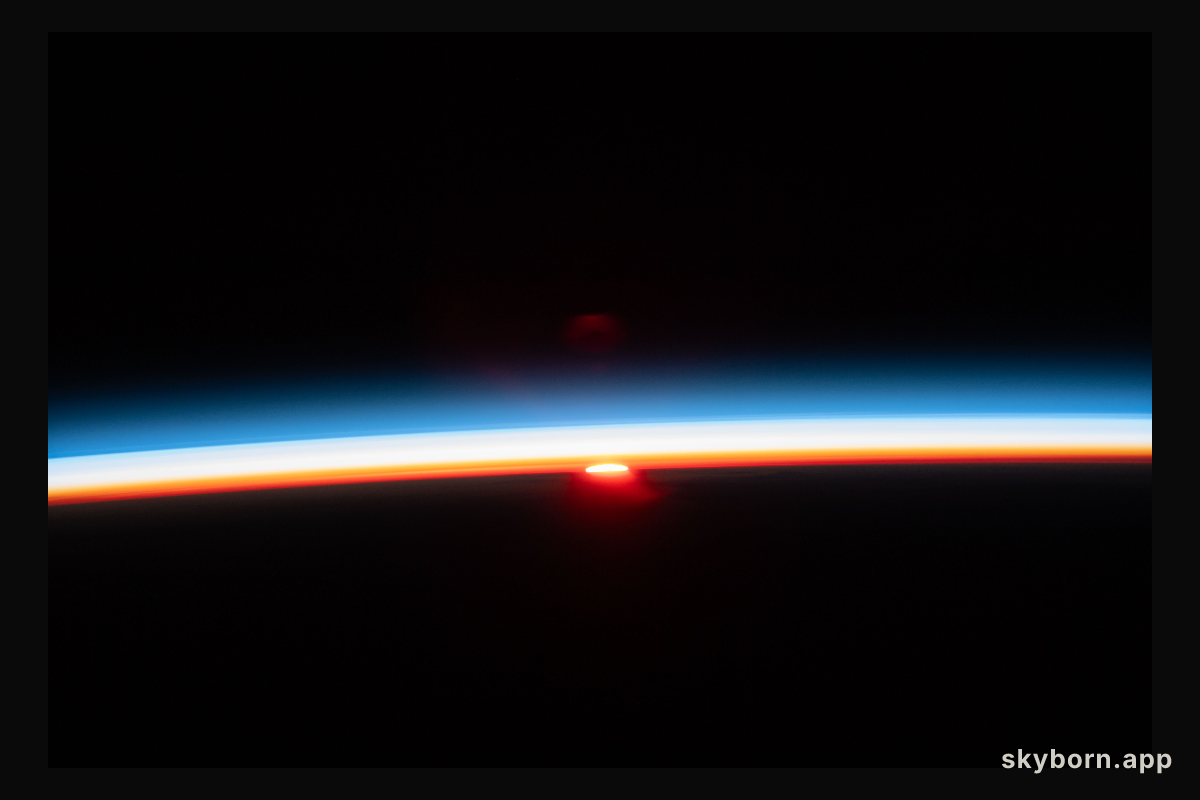 The sun's last rays illuminate Earth's atmosphere in this photograph of an orbital sunset from the International Space