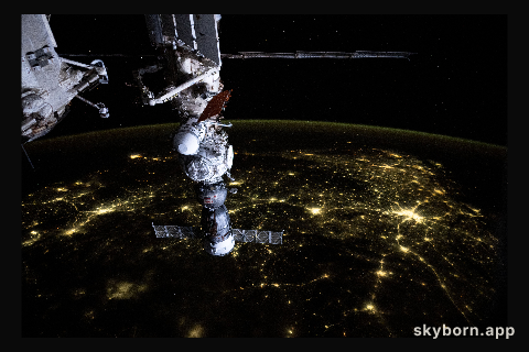 An atmosphreric glow blankets Earth's horizon and a web of city lights interconnect across India in this photograph