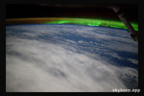 An aurora and an atmospheric glow crown Earth's horizon in this photograph from the International Space Station as it