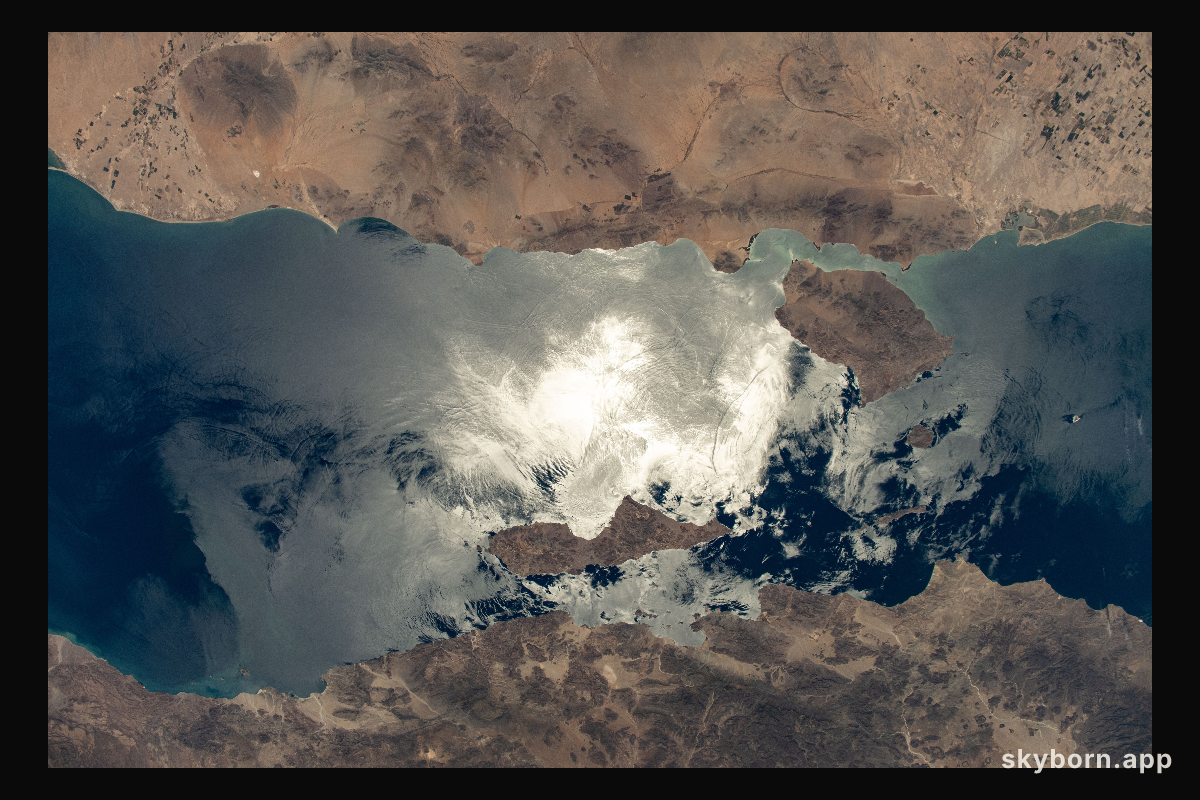 The sun's glint beams off the Gulf of California contrasting Mexico's coastal states of Baja California (bottom)