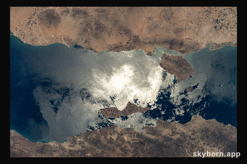 The sun's glint beams off the Gulf of California contrasting Mexico's coastal states of Baja California (bottom)