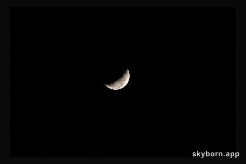 A waning crescent moon hangs against the black of space