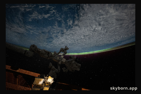 An aurora crowns Earth's horizon in this photograph from the International Space Station as it orbited 265 miles