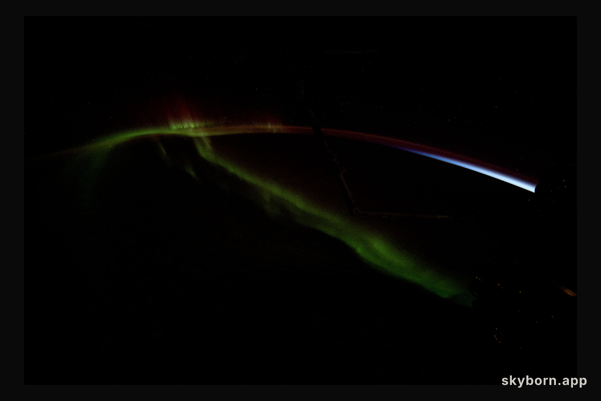 A wispy aurora australis streams over the Earth