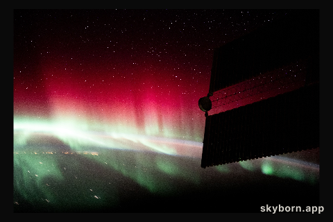A red and green aurora shimmers brightly above Ontario, Canada