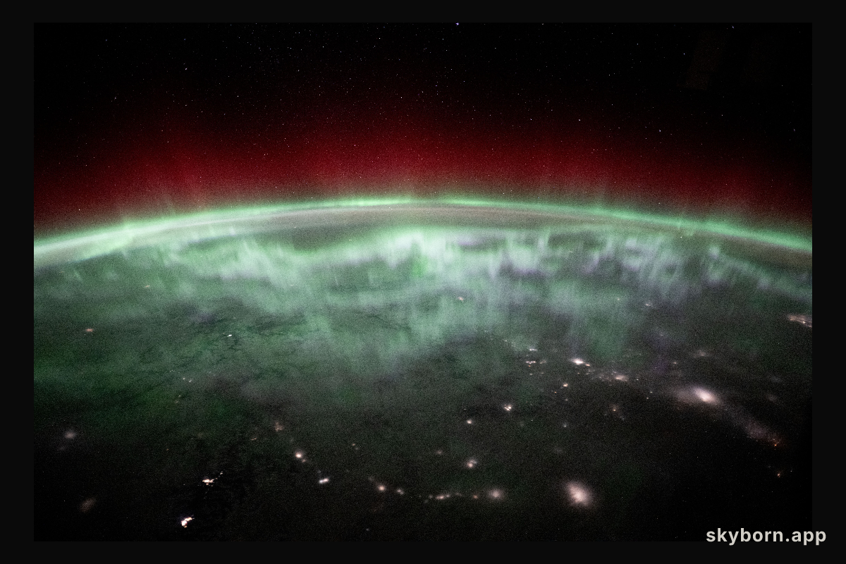 An aurora shimmers and dances above the city lights of Canada