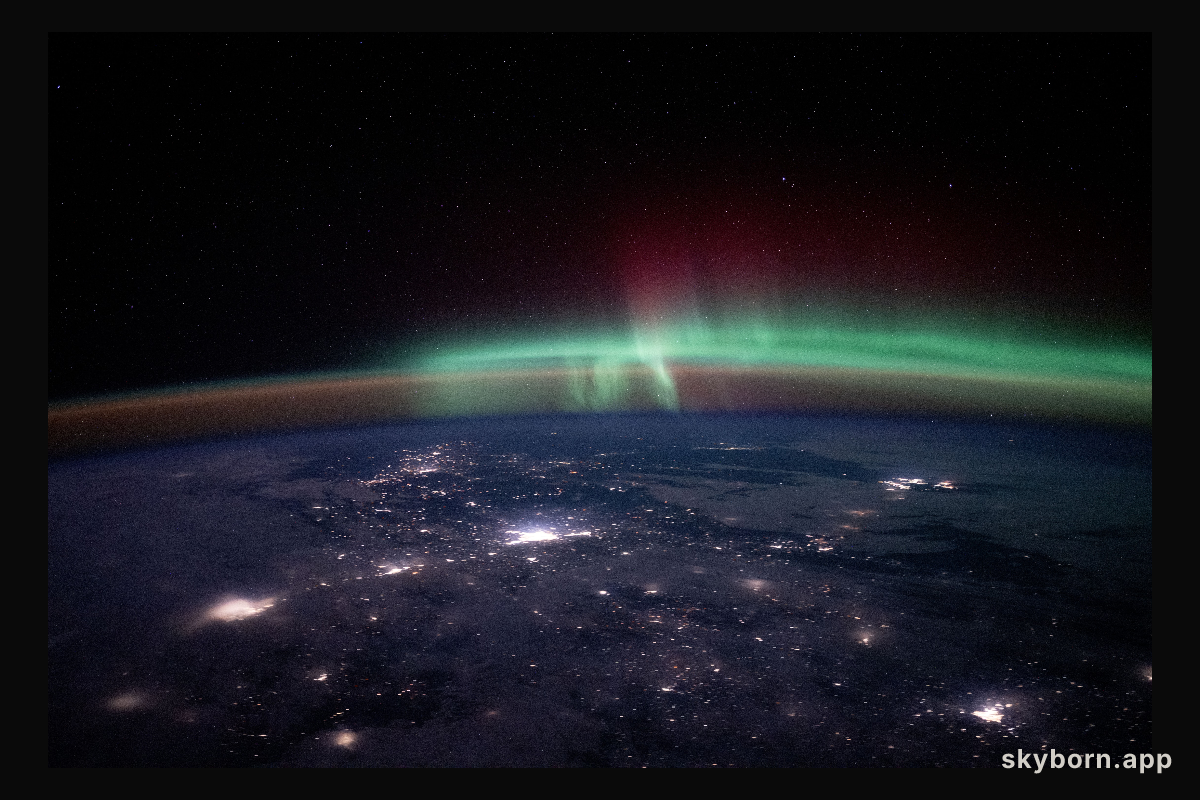City lights dot the Canadian landscape underneath an aurora