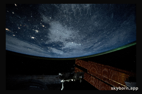 City lights dot the northeastern landscape of China with a wispy aurora above Earth's horizon