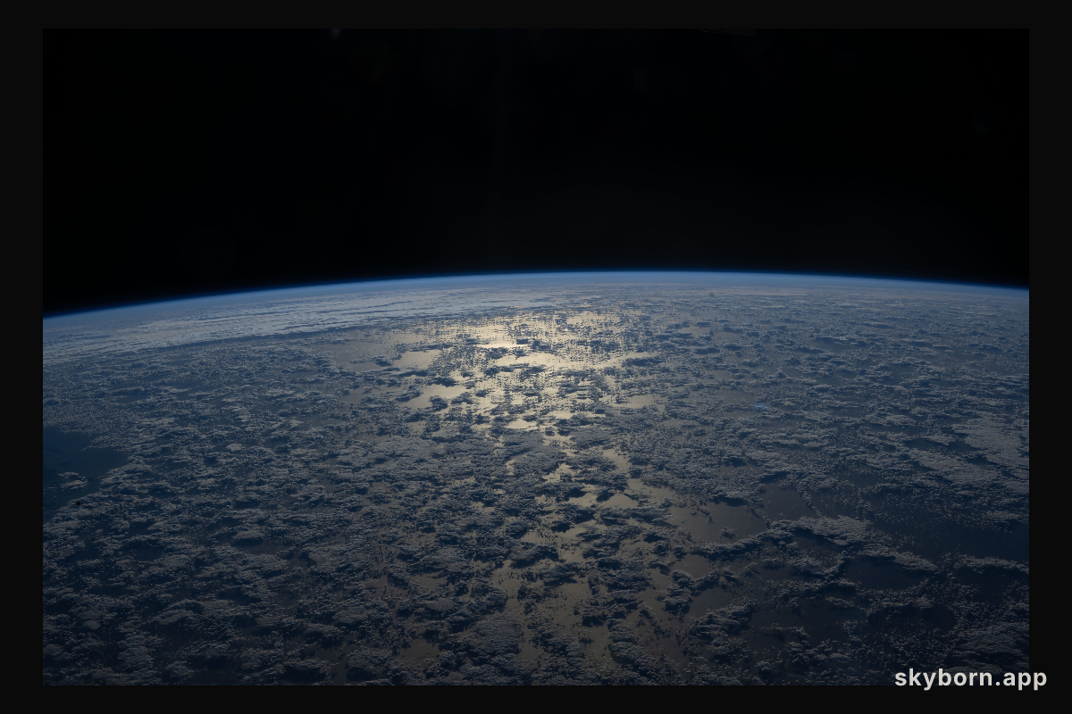 The Sun's glint beams off a partly cloudy Indian Ocean